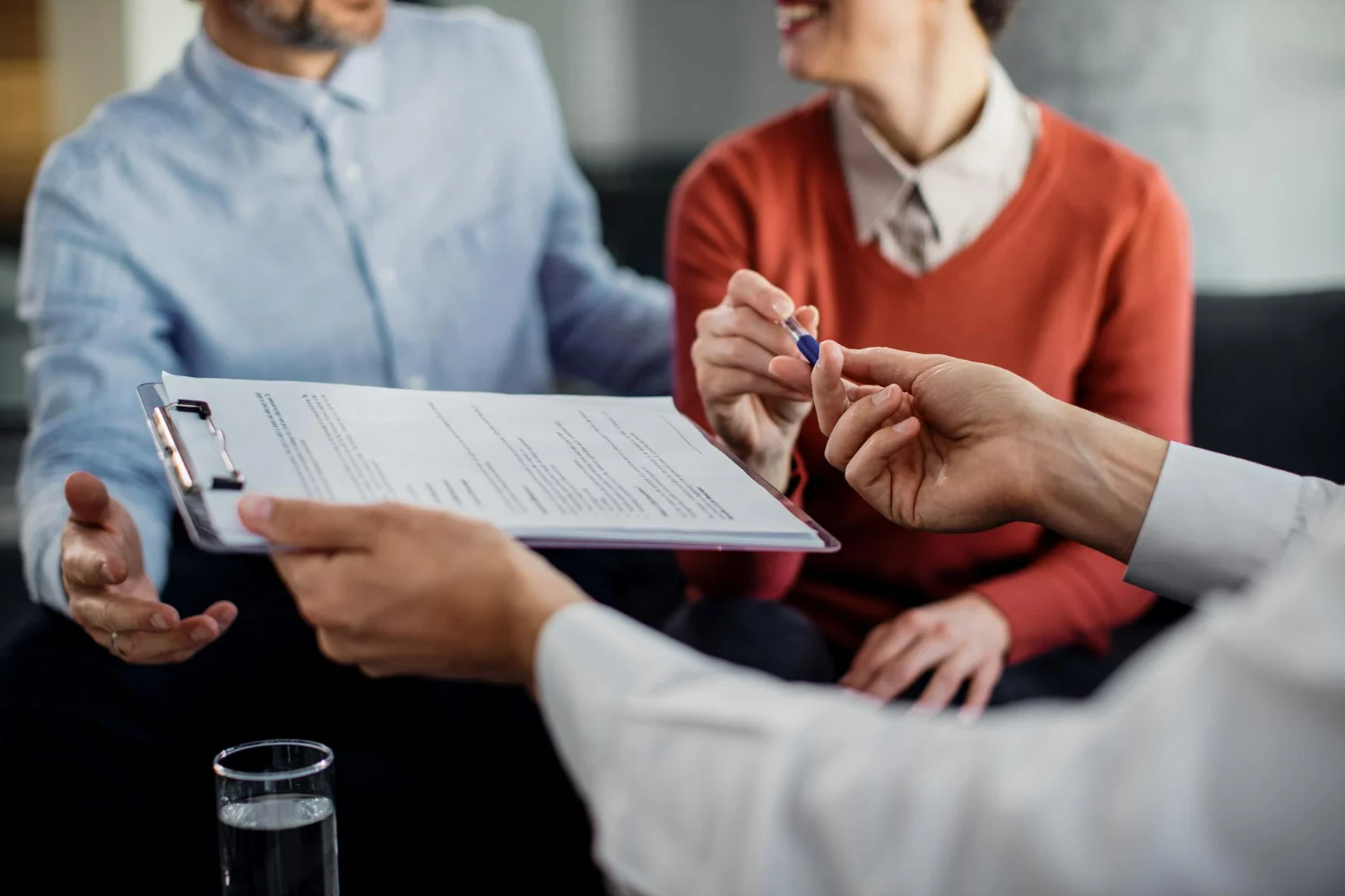 Casal analisa contrato com consultor antes de contratar um consórcio confiável